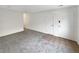 Unfurnished living room featuring neutral carpet, paint, and entryway to hallway at 9976 Appletree Pl, Thornton, CO 80260