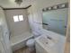 A bright bathroom featuring white tiled walls, a tub, and a modern sink at 1303 Havana St, Aurora, CO 80010