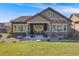 Charming backyard with a covered patio, stone accents, and lush green lawn at 360 Basilwood Way, Highlands Ranch, CO 80126