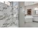 Bright bathroom featuring a glass shower with marble tile and decorative fleur-de-lis wall art above the tub at 360 Basilwood Way, Highlands Ranch, CO 80126
