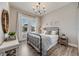 Cozy bedroom with natural light, wood flooring, a decorative chandelier and a comfortable iron bed frame at 360 Basilwood Way, Highlands Ranch, CO 80126