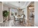 Elegant dining room with a round table, modern chandelier, and large window with natural light at 360 Basilwood Way, Highlands Ranch, CO 80126