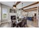Dining room with wooden beams, brick fireplace, modern lighting, and open concept design at 360 Basilwood Way, Highlands Ranch, CO 80126