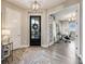Stylish foyer with wood floors, elegant lighting, and a view into a bright office through glass French doors at 360 Basilwood Way, Highlands Ranch, CO 80126