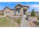 Charming single-Gathering home featuring a stone-accented facade, landscaped front yard, and inviting entryway with a covered porch at 360 Basilwood Way, Highlands Ranch, CO 80126