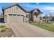Two-car garage with a long driveway offering ample parking, complemented by a well-maintained lawn and landscaping at 360 Basilwood Way, Highlands Ranch, CO 80126