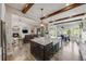 Modern kitchen with granite island, farmhouse sink, wooden beams, and open view to the living room at 360 Basilwood Way, Highlands Ranch, CO 80126