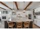Gourmet kitchen with a large island, granite countertops, white cabinets, and wood beams for a rustic touch at 360 Basilwood Way, Highlands Ranch, CO 80126