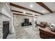 Comfortable living room featuring exposed wood beams, a stone accent wall, fireplace, and leather seating at 360 Basilwood Way, Highlands Ranch, CO 80126
