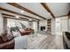 Cozy living room featuring a stone fireplace, wooden beam ceiling, and comfortable leather couches at 360 Basilwood Way, Highlands Ranch, CO 80126