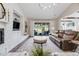 Comfortable living room with stone fireplace, media center, and sliding glass doors to backyard at 360 Basilwood Way, Highlands Ranch, CO 80126