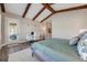 Tranquil bedroom features beamed ceilings, a sitting area, and a workspace near the exterior door at 360 Basilwood Way, Highlands Ranch, CO 80126