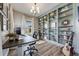 Modern home office featuring custom built-in shelving, a large window, and hardwood floors at 360 Basilwood Way, Highlands Ranch, CO 80126