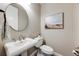 Chic powder room featuring a pedestal sink, round mirror, modern toilet, and sophisticated decor at 360 Basilwood Way, Highlands Ranch, CO 80126
