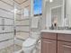 Modern bathroom features tiled walk-in shower, floating vanity and toilet in updated neutral tones at 9395 Night Star Pl, Lone Tree, CO 80124