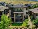 Beautiful three-story home featuring stone accents, balconies, and a well-maintained landscaped yard at 9395 Night Star Pl, Lone Tree, CO 80124