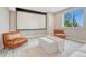 Bright living room with a movie screen, comfortable leather chairs, and a large window offering natural light at 9395 Night Star Pl, Lone Tree, CO 80124