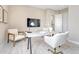 Office area showcases a large white desk, comfortable chairs, mounted TV and neutral walls at 9395 Night Star Pl, Lone Tree, CO 80124