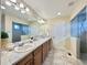 Spacious bathroom with a double sink vanity, marble countertops, and a glass-enclosed shower at 17955 E 107Th Pl, Commerce City, CO 80022