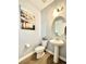 A well-lit half bathroom featuring a pedestal sink, white toilet and neutral colored walls at 17955 E 107Th Pl, Commerce City, CO 80022