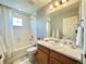 Well-lit bathroom with a tiled shower/tub and a single sink vanity with a white marble countertop at 17955 E 107Th Pl, Commerce City, CO 80022
