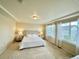 Bright bedroom with a tray ceiling, neutral walls, and large windows with sheer white curtains at 17955 E 107Th Pl, Commerce City, CO 80022