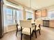 Bright dining area featuring a round table, hardwood floors, and natural wood cabinetry at 17955 E 107Th Pl, Commerce City, CO 80022