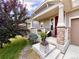 Inviting front porch featuring brick pillars, a cozy chair, and decorative potted plants at 17955 E 107Th Pl, Commerce City, CO 80022
