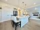 Bright open kitchen with large island, pendant lighting, and access to living room with fireplace at 17955 E 107Th Pl, Commerce City, CO 80022