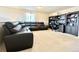 Open concept room with wall-to-wall carpet, a dark leather couch, and a large desk with built-ins at 17955 E 107Th Pl, Commerce City, CO 80022