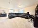 Spacious room with neutral carpet, a large sectional couch, and a desk with a computer at 17955 E 107Th Pl, Commerce City, CO 80022