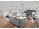 Kitchen island with bar stool seating flows into a living area with fireplace and vaulted ceilings at 751 Green Mountain Dr, Erie, CO 80516