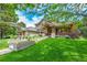 Stunning two-story home featuring a lush green lawn and charming architectural details at 2252 S Queen St, Lakewood, CO 80227