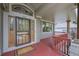 Inviting front porch with wooden accents, a red deck and decorative glass door at 2252 S Queen St, Lakewood, CO 80227