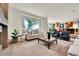 Cozy living room with a large window, plush seating, and a fireplace, perfect for relaxation at 2252 S Queen St, Lakewood, CO 80227