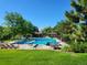 Community pool surrounded by lush landscaping, lounge chairs, and a lifeguard stand, perfect for summer relaxation at 2252 S Queen St, Lakewood, CO 80227