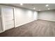 Spacious basement with neutral carpet, lighting, and white painted doors at 8426 W Woodard Dr, Lakewood, CO 80227