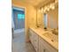 Bathroom showcasing dual sinks, granite countertops, and modern light fixtures at 8426 W Woodard Dr, Lakewood, CO 80227