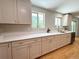 Well-lit kitchen with white cabinets, quartz countertops, and stainless steel dishwasher at 8426 W Woodard Dr, Lakewood, CO 80227