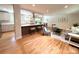 Open-concept living space with hardwood floors, kitchen island, and abundant natural light at 8426 W Woodard Dr, Lakewood, CO 80227