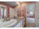 Pink bathroom showcasing a double vanity with framed mirrors, and a connected bedroom at 13205 E 109Th Ave, Commerce City, CO 80022