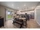 Bright, open-concept kitchen and dining area featuring white cabinets, stainless steel appliances, and backyard views at 13205 E 109Th Ave, Commerce City, CO 80022