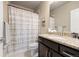 Well-lit bathroom boasts granite counters, dark wood cabinets, and a shower-tub combination at 756 Ranchhand Dr, Berthoud, CO 80513