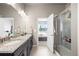 Bright bathroom featuring double vanity with granite countertops and a glass-enclosed shower at 756 Ranchhand Dr, Berthoud, CO 80513