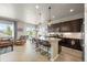 Open-concept kitchen with a large island, granite countertops, and dark wood cabinets at 756 Ranchhand Dr, Berthoud, CO 80513