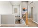 Well-lit staircase with wooden banister, leading to the upper level of the home at 756 Ranchhand Dr, Berthoud, CO 80513