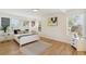 Bright bedroom featuring hardwood floors, large windows, and a comfortable bed with decorative pillows at 3866 S King St, Denver, CO 80236