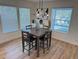 Dining area features a modern chandelier, a wood table, and lots of light from the three windows at 3866 S King St, Denver, CO 80236