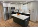 Modern kitchen featuring a large island, stainless steel appliances, two-tone cabinets, and beautiful hardwood floors at 3866 S King St, Denver, CO 80236