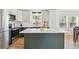 Modern kitchen features white cabinets, a center island, stainless steel appliances, and light hardwood flooring at 3866 S King St, Denver, CO 80236